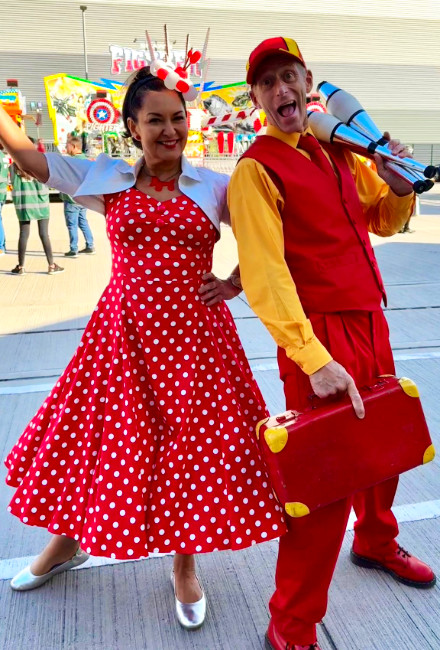 funday corporate entertainment Brett and an entertainer together at a corporate themed event, with company logo and identity, in bright yellow and red street entertainment show.